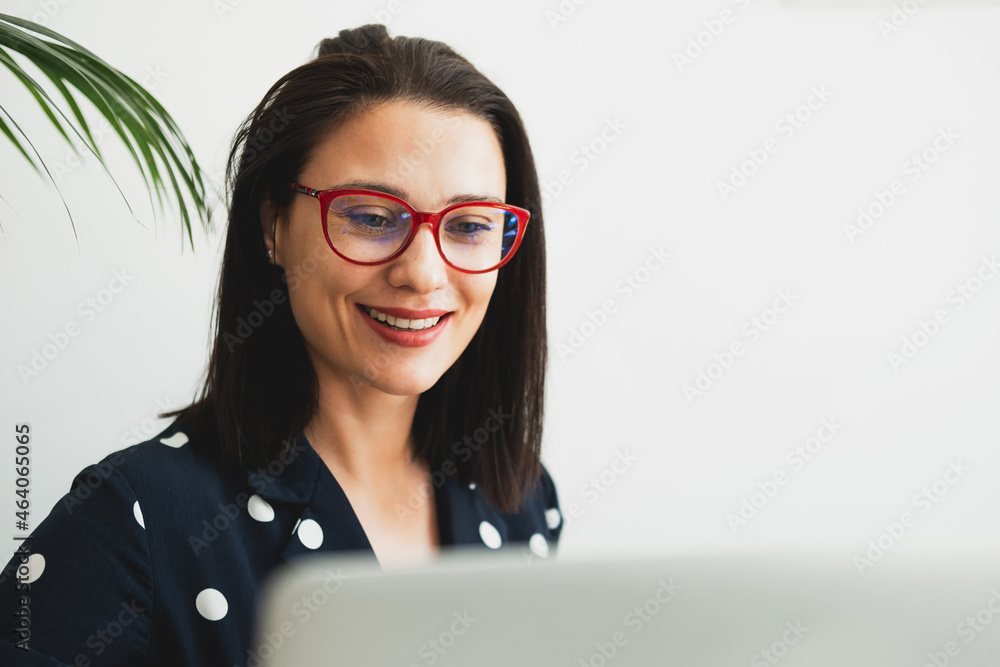 Beautiful woman sits in a cafe, drinks coffee, works on a computer and uses a phone Beautiful woman sits in a cafe, drinks coffee, works on a computer and uses a phone