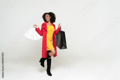 Young black woman smiling while walking with shopping bags