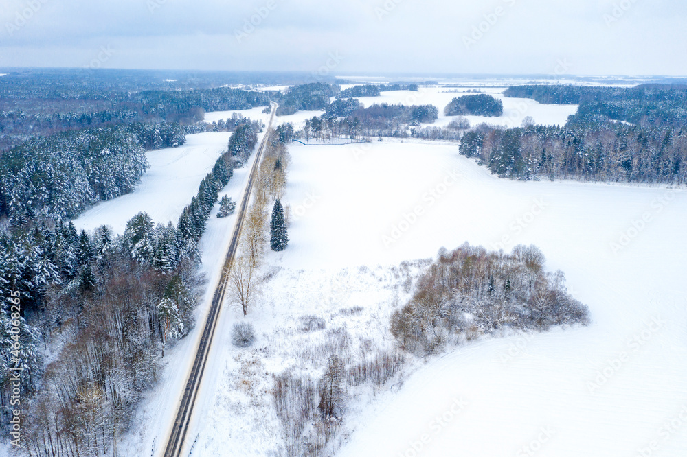 Aerial bird-eye view on freeway road in the winter forest
