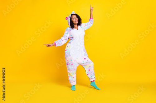 Full length photo of young afro woman happy positive smile dance party sleepover point fingers isolated over yellow color background