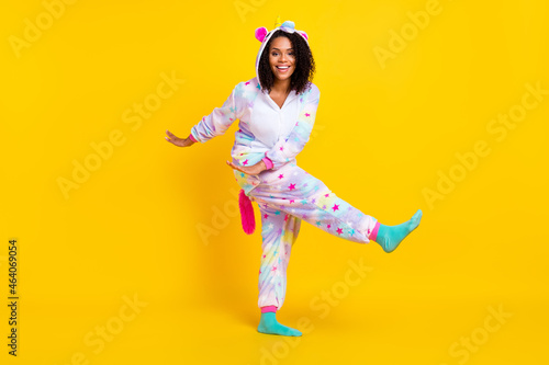 Full length body size view of pretty cheerful girl wearing funny pajama dancing isolated over bright yellow color background photo