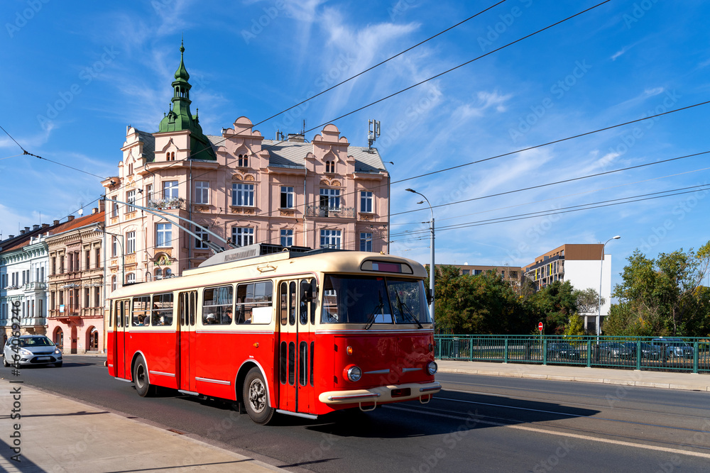 Fototapeta premium Red omnibus runs through the Pilsen city centre, Czech republic