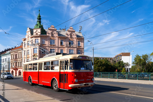 Red omnibus runs through the Pilsen city centre, Czech republic