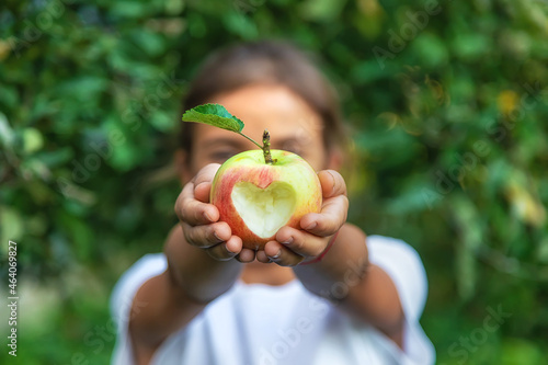 Foto The child eats an apple in the garden. Selective focus.