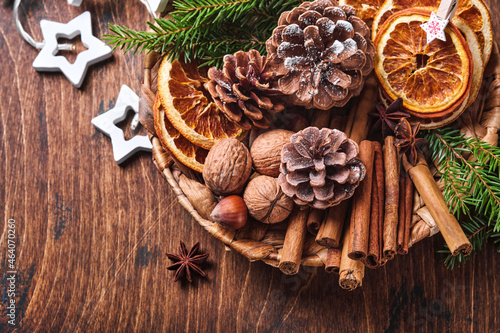 Dry orange, star anise, cinnamon, pine cones and fir tree in rustic plate on wooden table. Homemade medley idea for Christmas mood and aroma. Eco friendly christmas with homemade natural decorations.