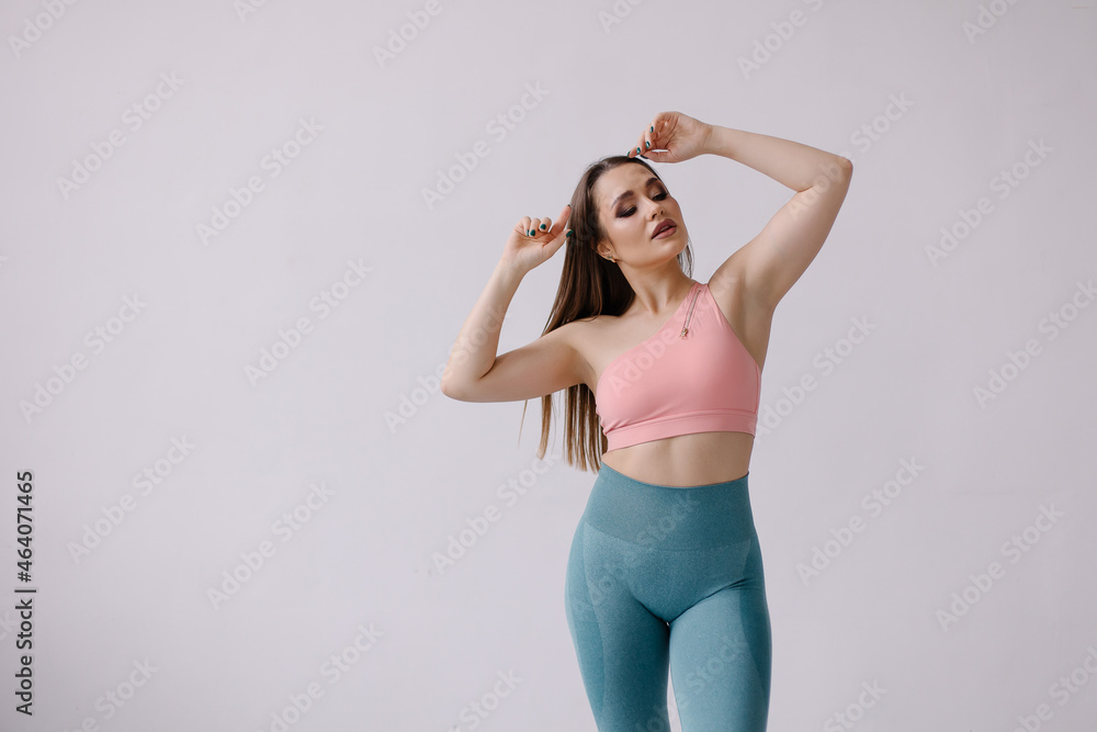 Confident pose of fitness trainer portrait. Fashion woman in sportswear. Strong beautiful sportswoman with make-up. Lifestyle. Sportive curvy sensual girl with a muscular figure. Healthy gym workout Confident pose of fitness trainer portrait. Fashion woman in sportswear. Strong beautiful sportswoman with make-up. Lifestyle. Sportive curvy sensual girl with a muscular figure. Healthy gym workout