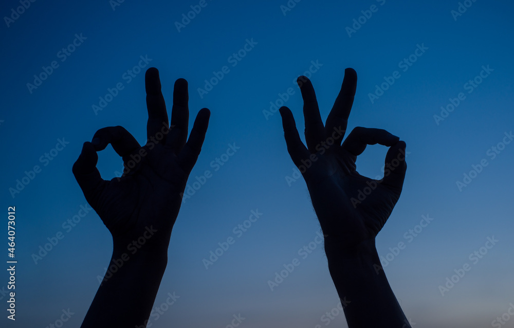Sign ok silhouette. Two man hand shows sign okay. Silhouette. Sign okay. Ok.