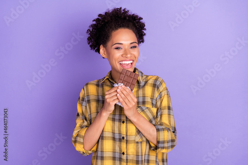Photo of young african girl happy positive smile eat chocolate yummy diet isolated over purple color background