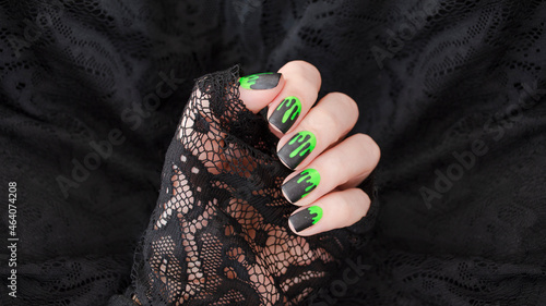 Close up womans hand with halloween spooky manicure on black background.