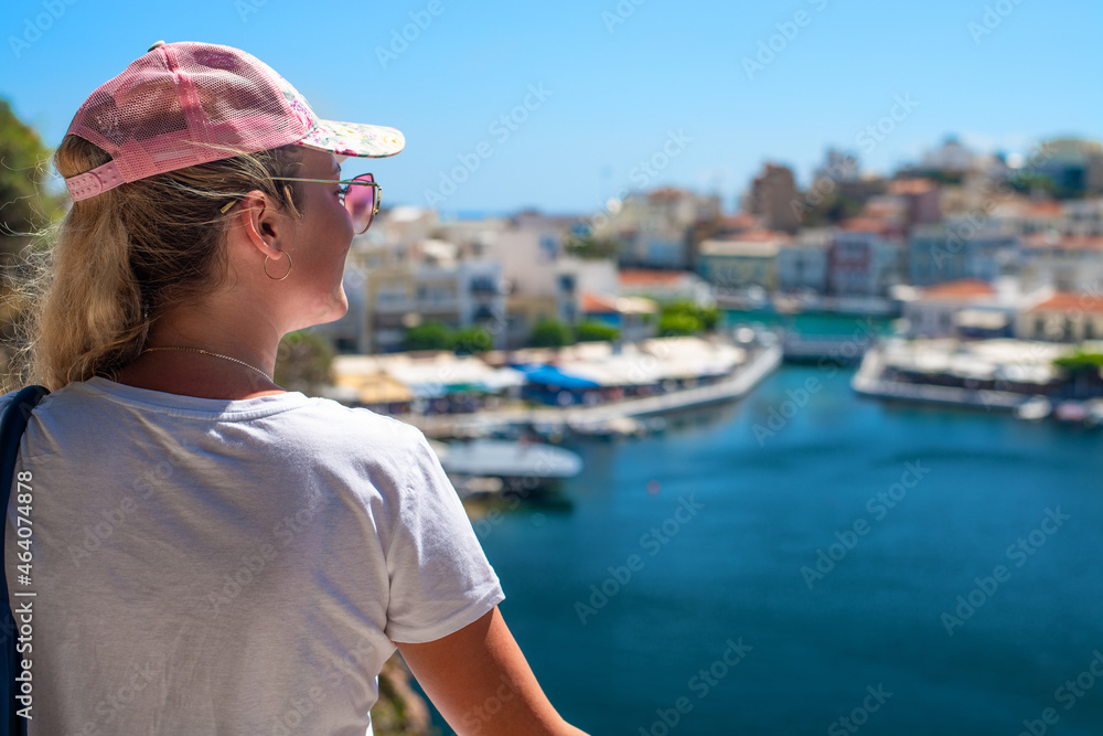 a girl in a pink cap and glasses looks at a European city