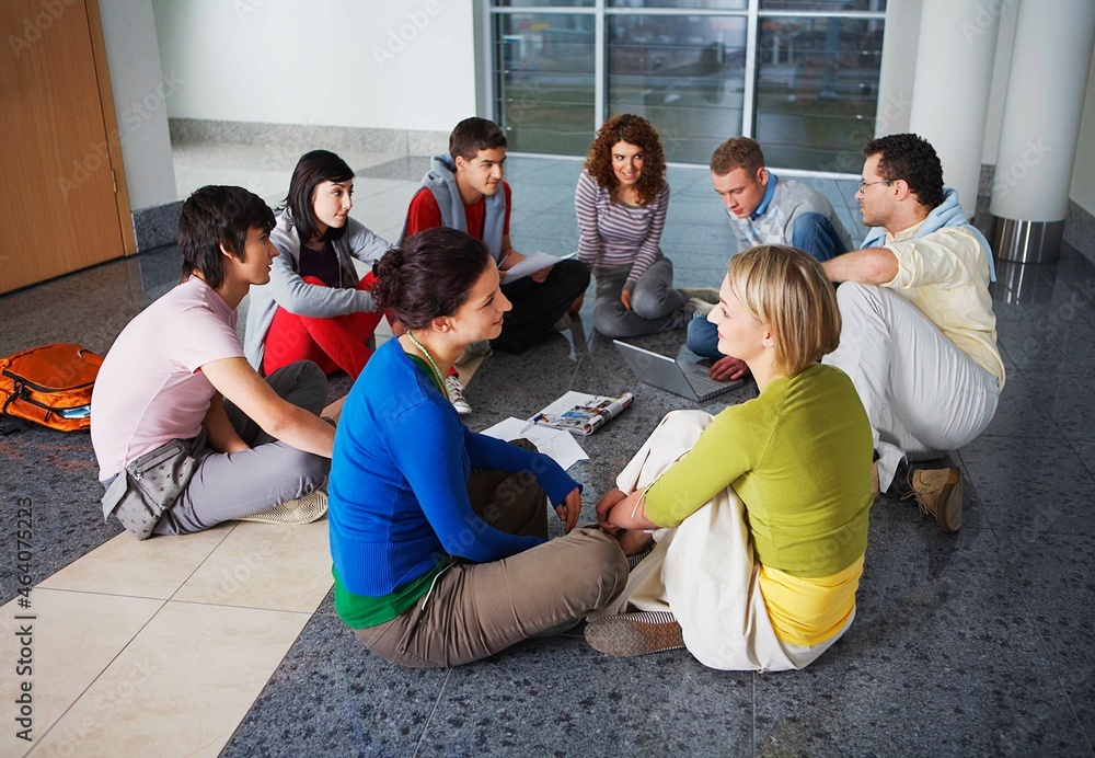 University students sitting on floor in hallway University students sitting on floor in hallway