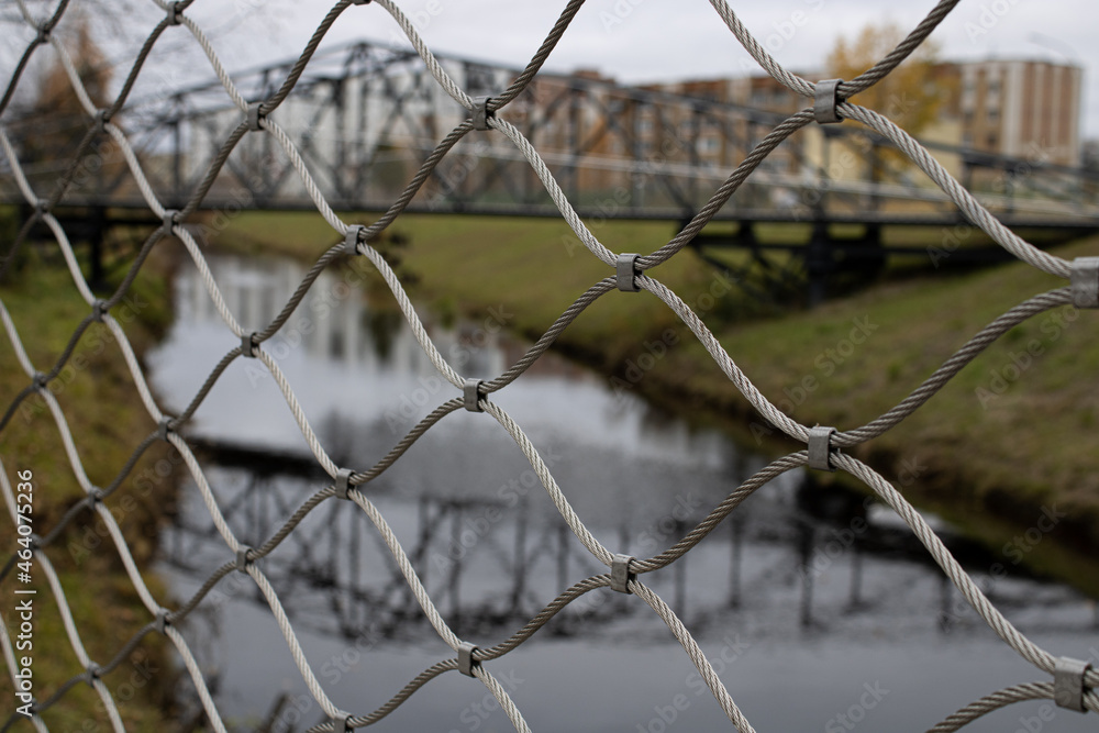 View of the bridge, river and houses through the net View of the bridge, river and houses through the net