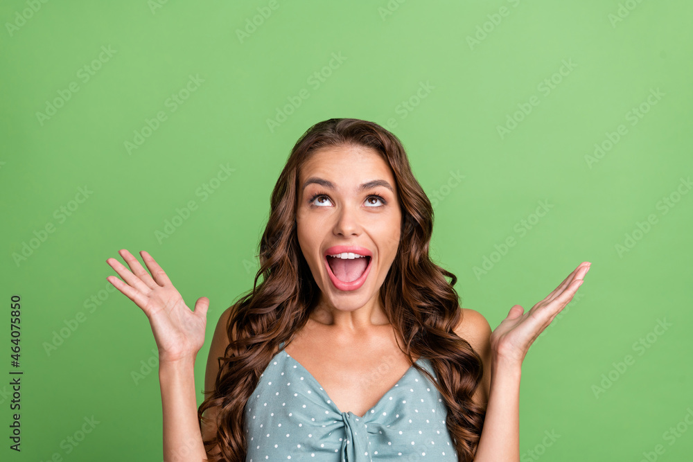 Photo of young girl happy positive smile amazed shocked omg wow news discount look empty space isolated over green color background Photo of young girl happy positive smile amazed shocked omg wow news discount look empty space isolated over green color background