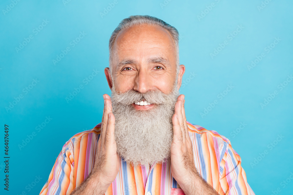 Photo of senior man happy positive smile hands touch beard barber shop haircare isolated over blue color background Photo of senior man happy positive smile hands touch beard barber shop haircare isolated over blue color background