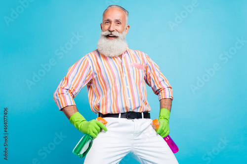Photo of senior man happy positive smile cleaning household disinfection spray isolated over blue color background