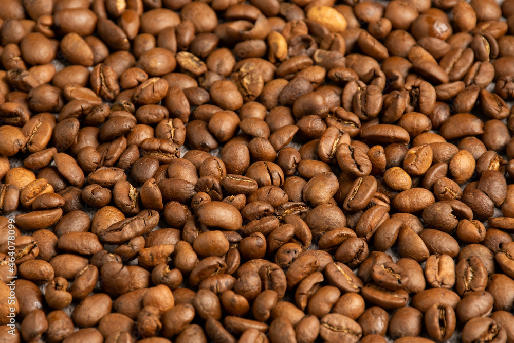 Coffee beans are roasted over medium heat and placed on the kitchen table. Closeup, Selective focus, black, blurred background