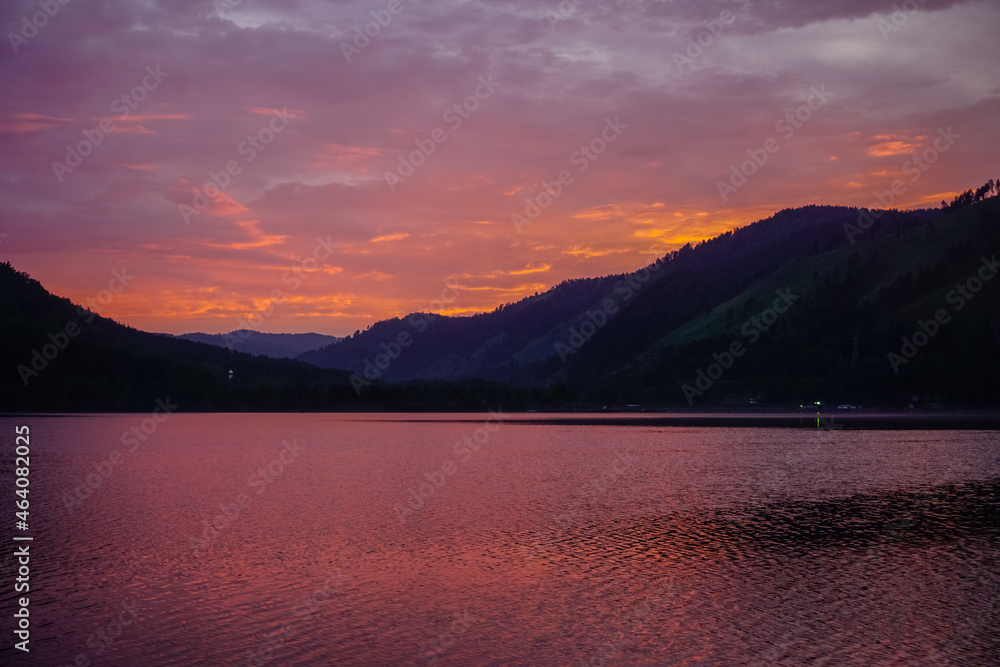 Beautiful Sayan mountains in the reflection of the Yenisei river at sunset Beautiful Sayan mountains in the reflection of the Yenisei river at sunset