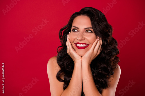 Portrait of attractive glamorous dreamy nude cheerful wavy-haired girl fantasizing copy space isolated over bright red color background