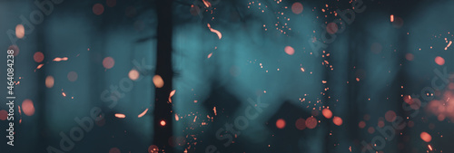 3d rendering of particles of fire in front of spooky blue forest at night photo