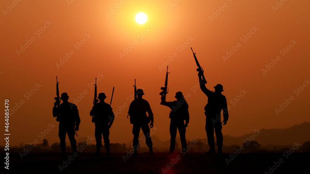 Silhouette of military soldier or officer with weapons at sunset. shot, holding gun, standing in a row colorful sky, background