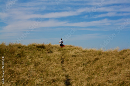 Man Walking Over a Sand Dune, Norfolk, UK