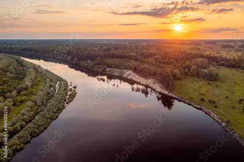 Drone photo of big river with setting sun on the background. Beautiful landscape of calm rural nature