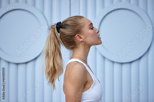 Portrait of young woman in front of blue wall photo