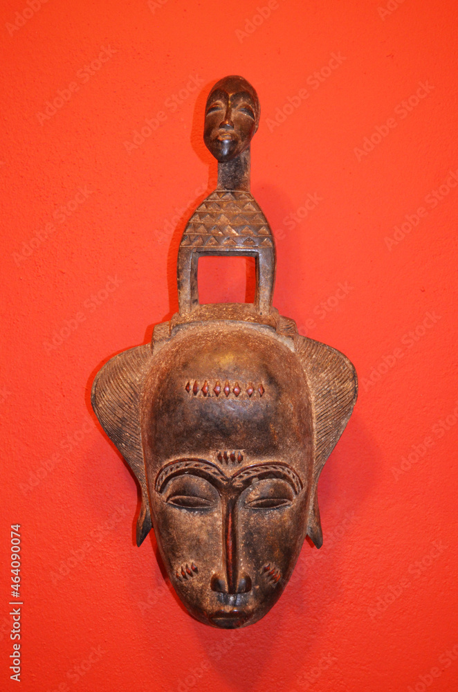 African mask on a red isolated background.