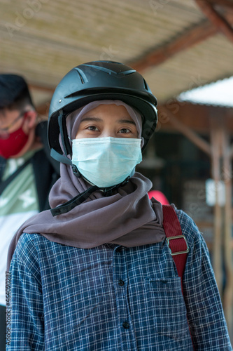 portrait of asian muslim woman wearing sports helmet and mask © itsuky