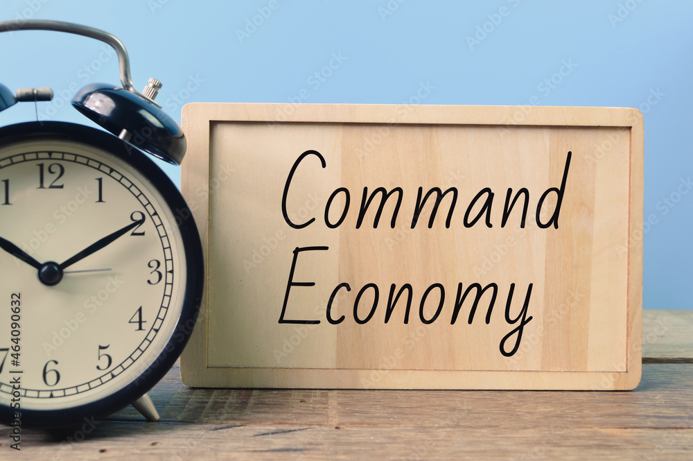 Alarm clock and wooden board written with text COMMAND ECONOMY Alarm clock and wooden board written with text COMMAND ECONOMY