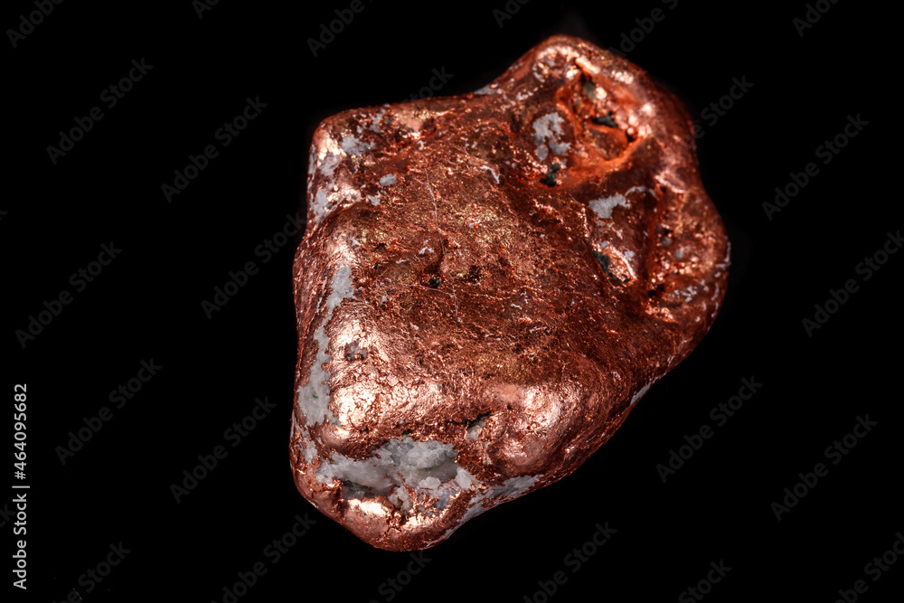 Macro mineral stone of a copper nugget on a microcline on a black background