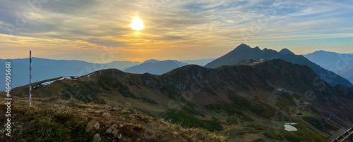 Mountains of the Caucasian ridge in autumn, at sunset. Snow-capped peaks can be seen in the distance © Ирина У