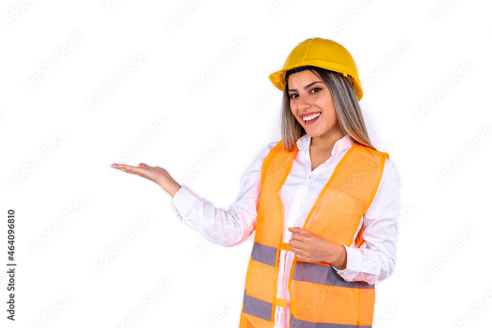 Beautiful young female engineer or supervisor, wearing safety gear, pointing to the side on white background with room for text or copy space. Concept of empowered woman, professional woman. Beautiful young female engineer or supervisor, wearing safety gear, pointing to the side on white background with room for text or copy space. Concept of empowered woman, professional woman.