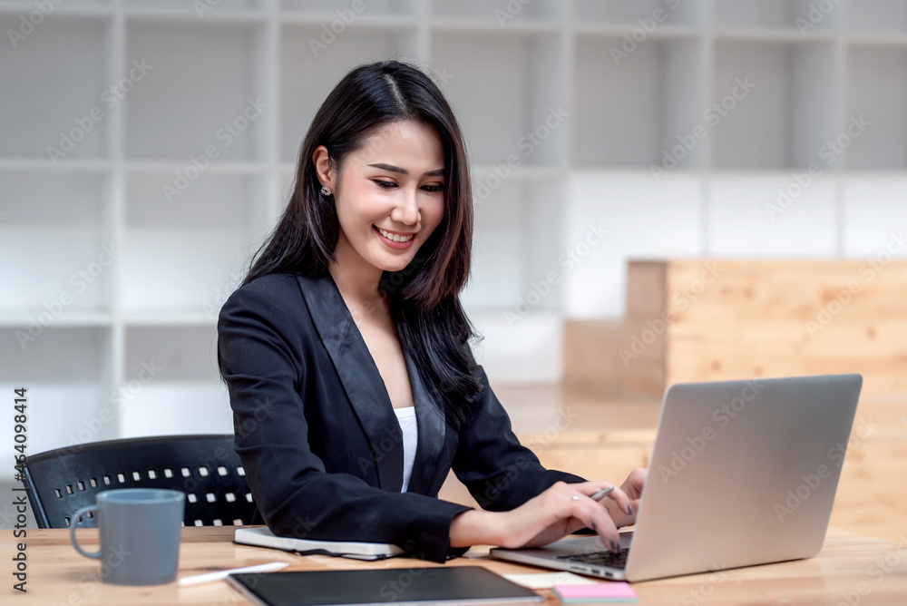 Charming young Asian businesswoman working on laptop keyboard at office. Charming young Asian businesswoman working on laptop keyboard at office.