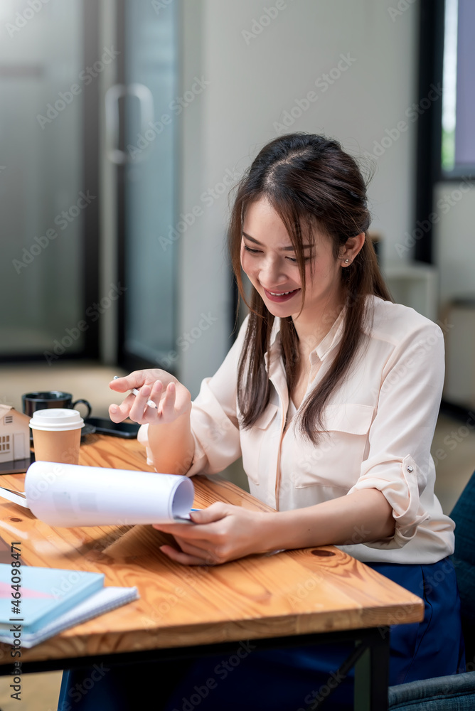 Happy young Asian businesswoman to work holding documents at the office. Happy young Asian businesswoman to work holding documents at the office.