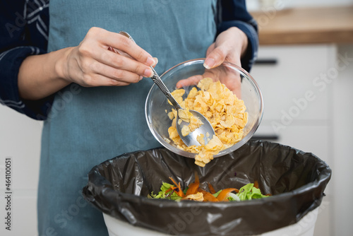 global food pollution concept. Woman throwing a leftover breakfast to the trash.