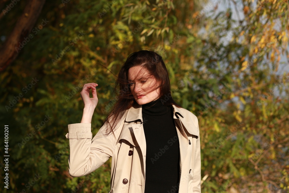 Brunette woman in a coat outside in autumn Brunette woman in a coat outside in autumn