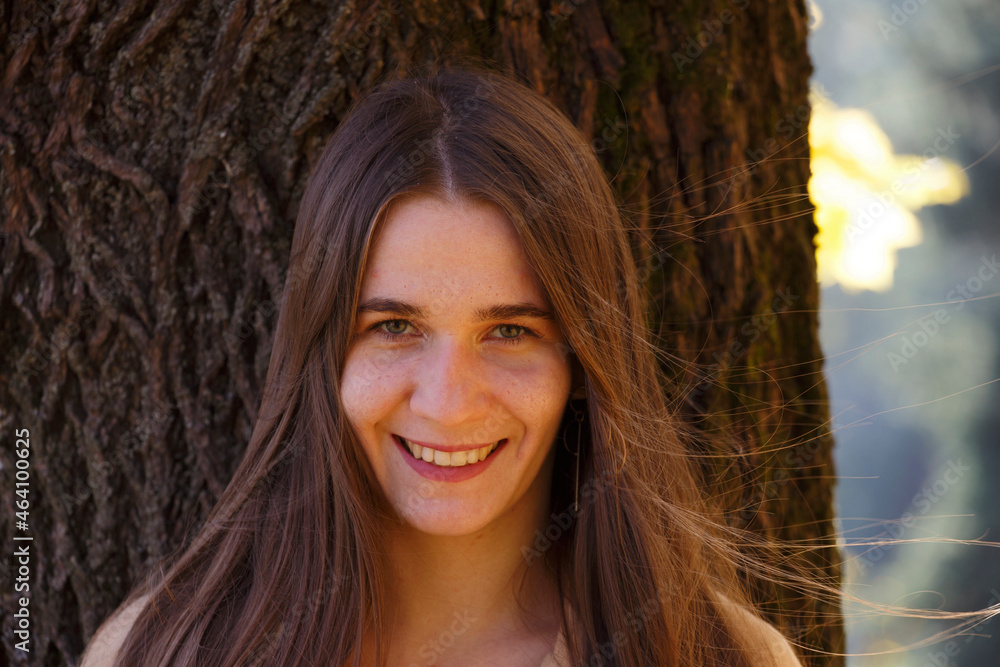 Portrait of a beautiful close-up of a beautiful girl on the background of the bark of a thick tree. Portrait of a beautiful close-up of a beautiful girl on the background of the bark of a thick tree.