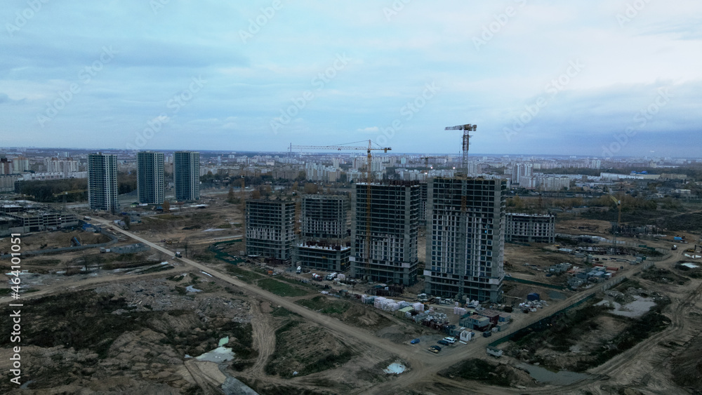 Construction of modern multi-storey buildings. Construction of a new city block. Buildings under construction site. Aerial photography in cloudy weather.