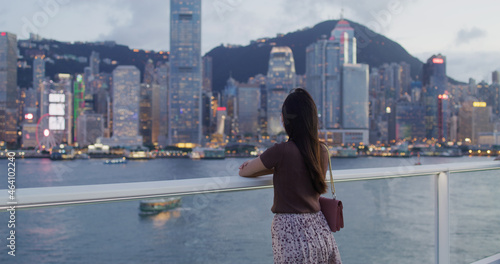 Woman wear face mask and look at the city of Hong Kong