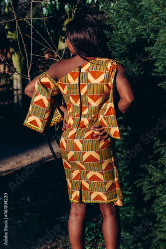 Wallpaper Mural Beautiful African black woman walking in park. Pretty young woman with brown skin wearing African print dress in a tribal kente pattern Torontodigital.ca