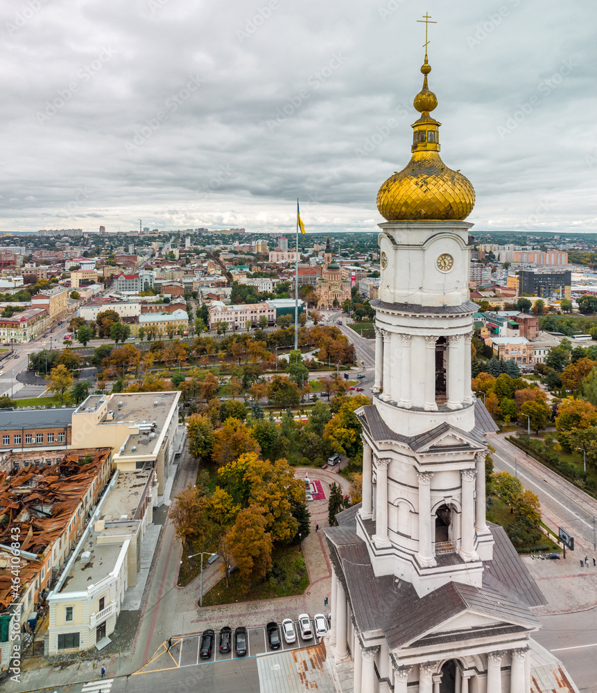 Autumn Dormition Cathedral dome close-up view. European city aerial view on downtown roofs with gray heavy clouds in Kharkiv, Ukraine