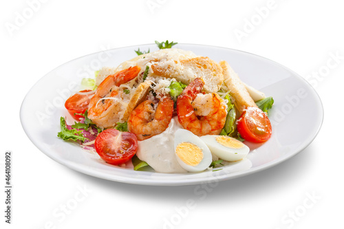 caesar salad with shrimps on a white plate, close-up, isolate