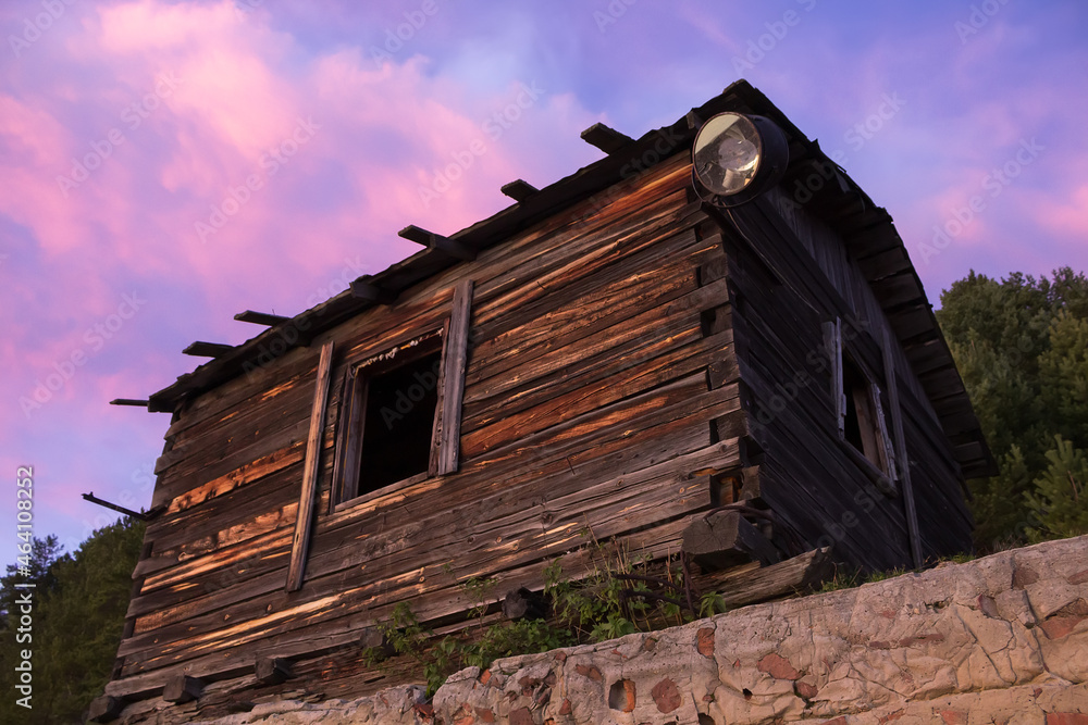 Abandoned old wooden house. Sunset