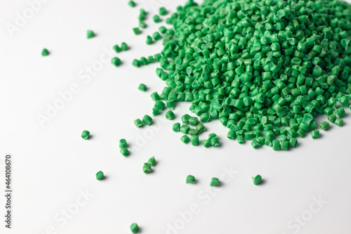 Green granules of polypropylene or polyamide on a white background. Plastics and polymers industry. Copy space. 