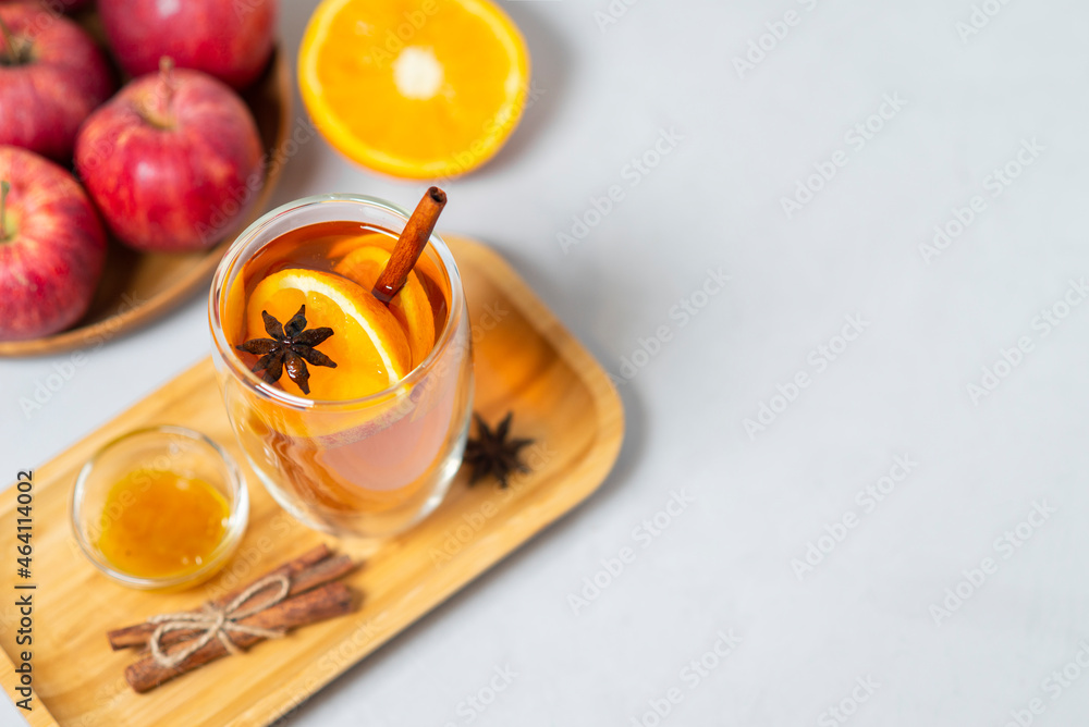 Hot apple honey cider on light background. Traditional Christmas or New Year warming spicy beverage with cinnamon, star anise, orange. Non-alcoholic drink recipe idea for cold weather, copy space Hot apple honey cider on light background. Traditional Christmas or New Year warming spicy beverage with cinnamon, star anise, orange. Non-alcoholic drink recipe idea for cold weather, copy space
