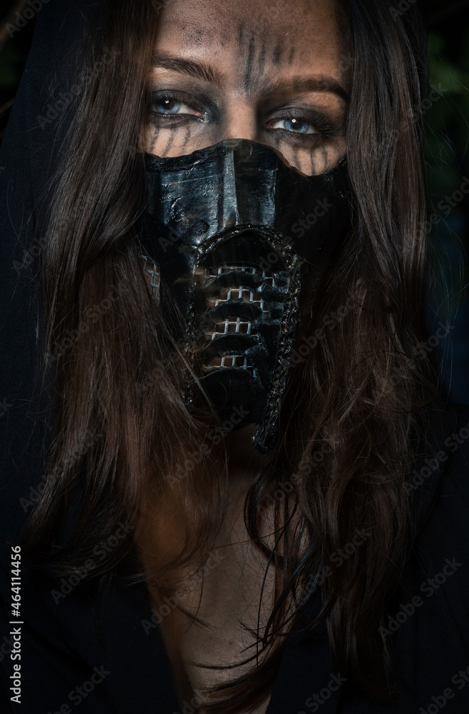 A girl in a black mask and war paint. Selective focus. A girl in a black mask and war paint. Selective focus.
