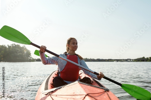 Caucasian woman floating on kayak in lake or river