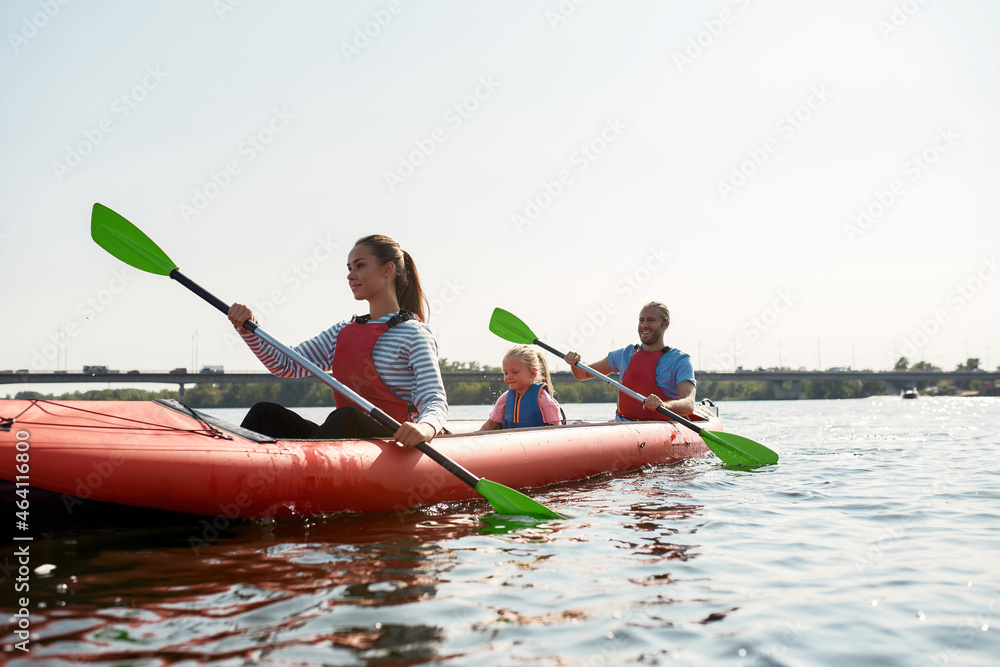 Young european family floats on kayak in lake