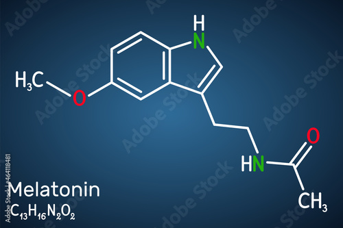 Melatonin molecule, hormone that regulates sleep and wakefulness. Structural chemical formula on the dark blue background photo